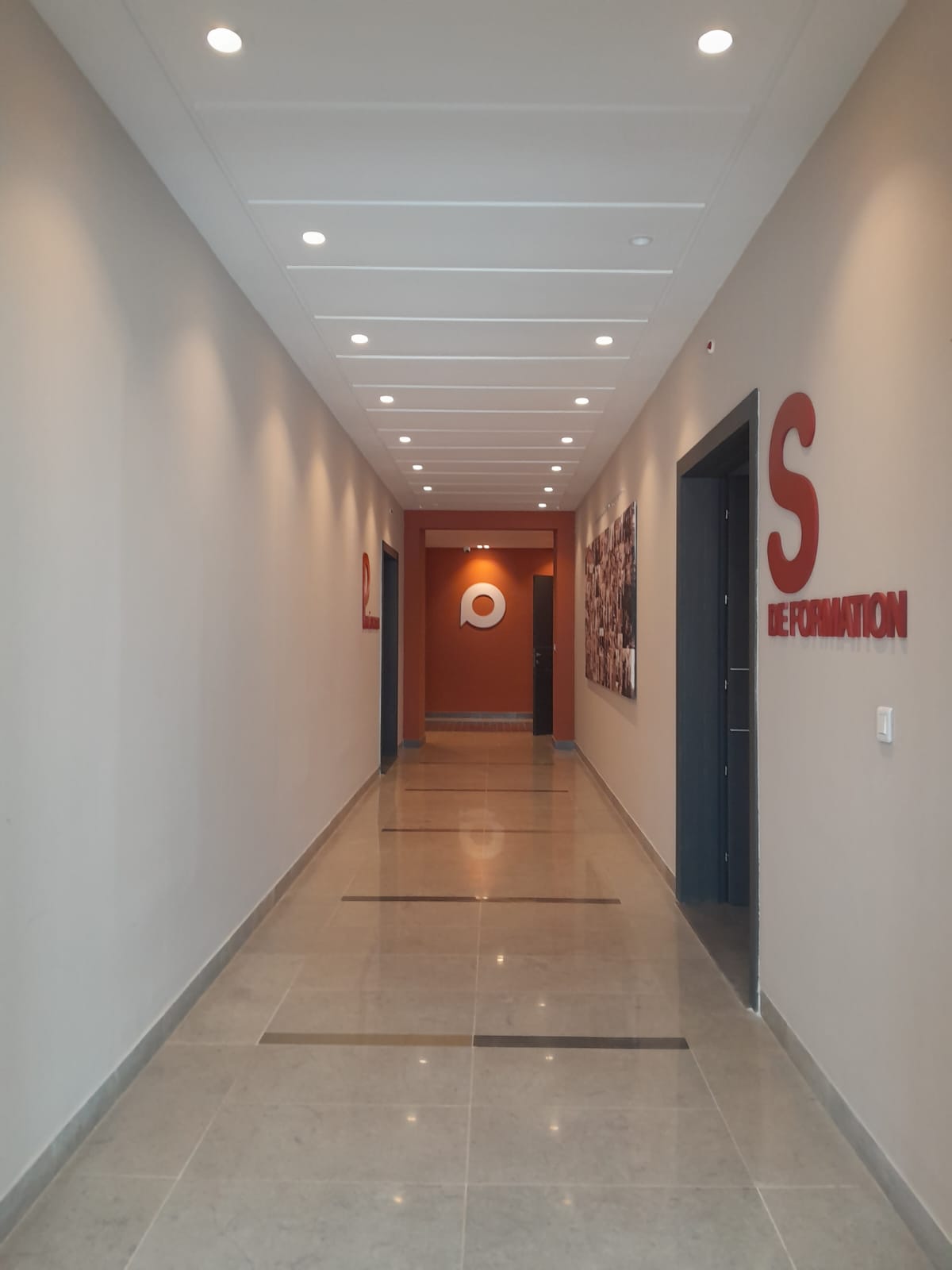 Training and onboarding hallway at PolyCall HQ, with employee portraits wall